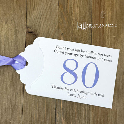 Celebrate with milestone birthday party guest favors that they will treasure. Each favor is customized with names, dates and a special messages to make your event unforgettable. Perfect for 30th, 40th, 50th, and beyond—these keepsakes add a personal touch to any milestone celebration.&nbsp; &nbsp;Printed on white cardstock with your choice of large number and ribbon color to match your party theme.