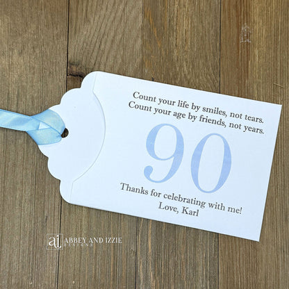 Celebrate with milestone birthday party guest favors that they will treasure. Each favor is customized with names, dates and a special messages to make your event unforgettable. Perfect for 30th, 40th, 50th, and beyond—these keepsakes add a personal touch to any milestone celebration.&nbsp; &nbsp;Printed on white cardstock with your choice of large number and ribbon color to match your party theme.