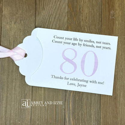 Celebrate with milestone birthday party guest favors that they will treasure. Each favor is customized with names, dates and a special messages to make your event unforgettable. Perfect for 30th, 40th, 50th, and beyond—these keepsakes add a personal touch to any milestone celebration.&nbsp; &nbsp;Printed on white cardstock with your choice of large number and ribbon color to match your party theme.