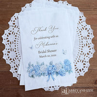 Personalized blue hydrangea bridal shower favors bags, perfect for a small gift of appreciation or a cookie bar or even a candy bar.  White bags adorned with delicate blue hydrangeas for a sweet addition to your event.
