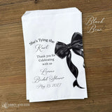 Send your guests home with a memorable keepsake from the bride-to-be's special day with our She's Tying the Knot Bridal Shower Favor Bags . These charming favor bags feature a playful "She's Tying the Knot" design that perfectly captures the excitement of bridal shower celebrations.  Adorned with a black or Pink bow, your choice and personalized for the bride to be.  Printed on white bags, larger than most.