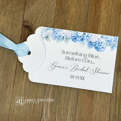 Celebrate the bride-to-be with our Something Blue Bridal Shower Favors—a charming way to honor tradition while delighting your guests. Each favor features beautiful blue hydrangeas, perfect for that 'something blue before I say I do theme'. Personalize with name and date to create a keepsake your guests will treasure. Slide a scratch off card in the open end to add some excitement to the event. Printed on sturdy white card stock with blue ribbon attached. Ideal for adding an elegant touch.