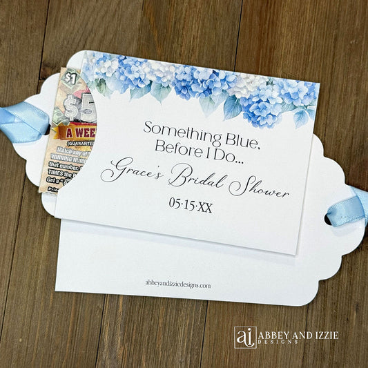 Celebrate the bride-to-be with our Something Blue Bridal Shower Favors—a charming way to honor tradition while delighting your guests. Each favor features beautiful blue hydrangeas, perfect for that 'something blue before I say I do theme'. Personalize with name and date to create a keepsake your guests will treasure. Slide a scratch off card in the open end to add some excitement to the event. Printed on sturdy white card stock with blue ribbon attached. Ideal for adding an elegant touch.