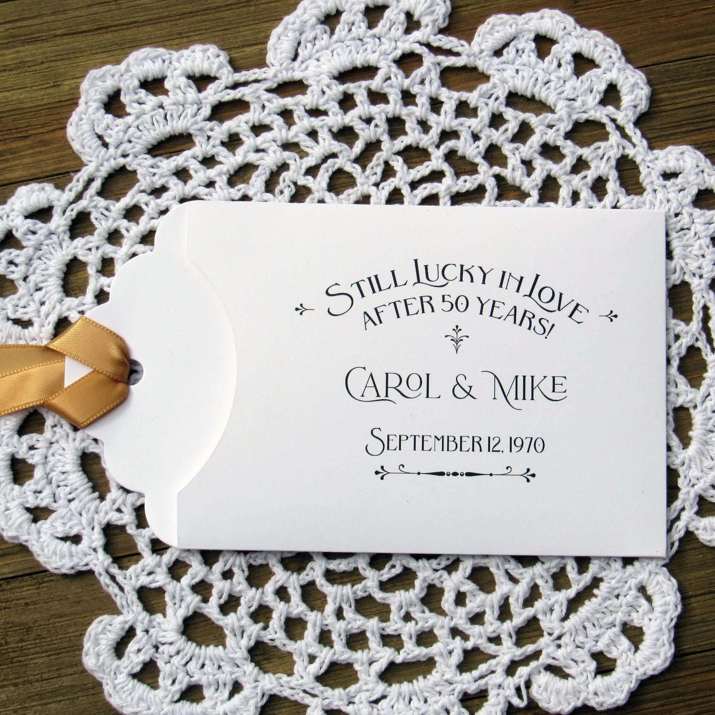 Our  Lucky In Love 50th Anniversary Favors are personalized for the happy couple.  Still lucky in lover after 50 years printed on white envelopes with gold ribbon attached.  Slide a lottery ticket in the open end for a fun favor guest will love.