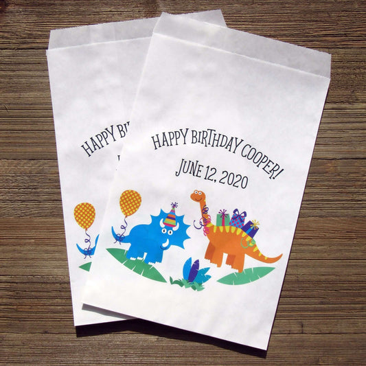 Fun Dinosaur Birthday Treat Bags personalized for the guest of honor.  Adorable dinosaurs printed on a white bag, larger than most so can be used for many items.