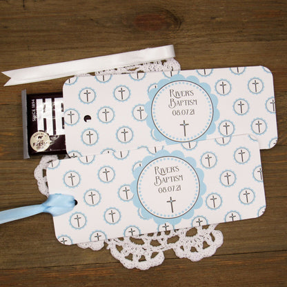 Personalized Baptism Party Favors for Baby Boys.  Printed on white card stock adorned with blue crosses with babies name and baptism date.  Choice of light blue or white ribbon which is included and left off for easy filling.  Slide a candy bar in the open end and tie the ribbon.