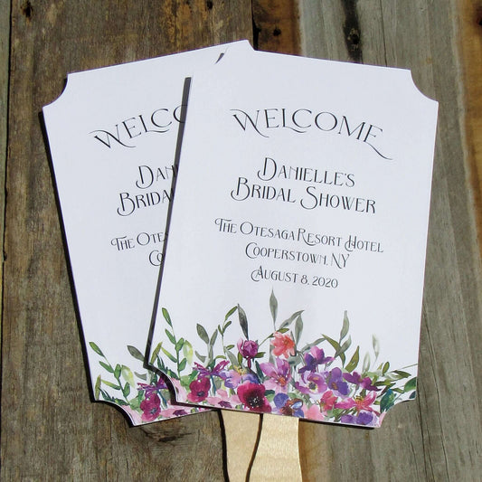 Bridal Shower Favor Fans Personalized, printed on white card stock and adorned with purple flowers.  Such a welcome favor on a warm summer day and a nice keepsake for everyone to take home.