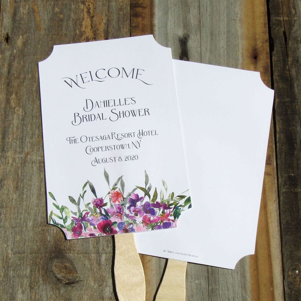 Bridal Shower Favor Fans Personalized, printed on white card stock and adorned with purple flowers.  Such a welcome favor on a warm summer day and a nice keepsake for everyone to take home.