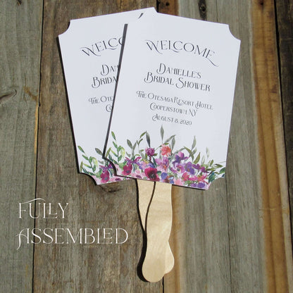 Bridal Shower Favor Fans Personalized, printed on white card stock and adorned with purple flowers.  Such a welcome favor on a warm summer day and a nice keepsake for everyone to take home.