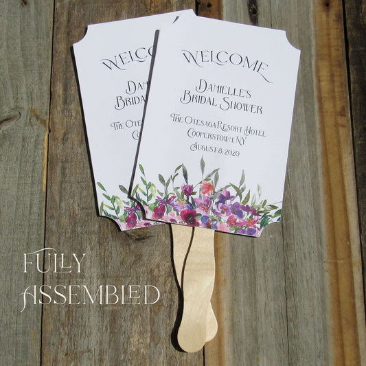Bridal Shower Favor Fans Personalized, printed on white card stock and adorned with purple flowers.  Such a welcome favor on a warm summer day and a nice keepsake for everyone to take home.