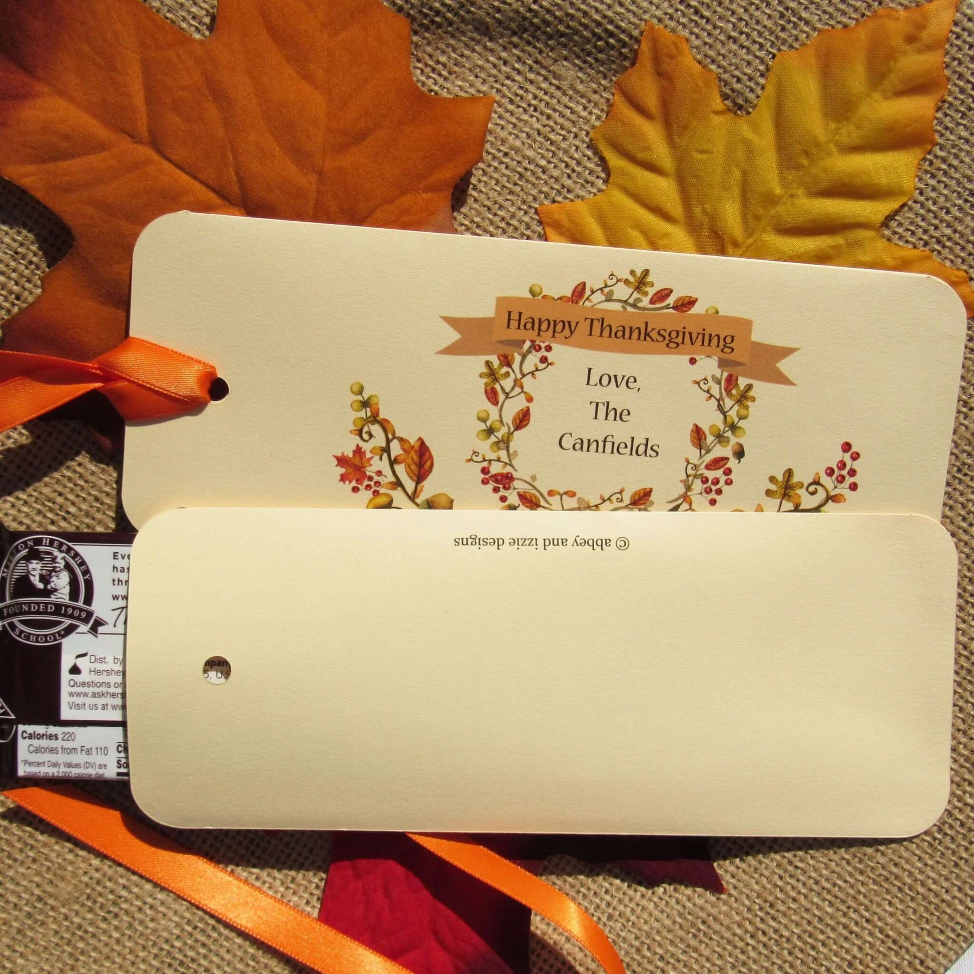 Thanksgiving Table Candy Favors that are personalized for a elegant touch.  Constructed from ivory card stock, these are sturdy candy bar favors, just slide the candy bar in the open end and tie the ribbon on.  