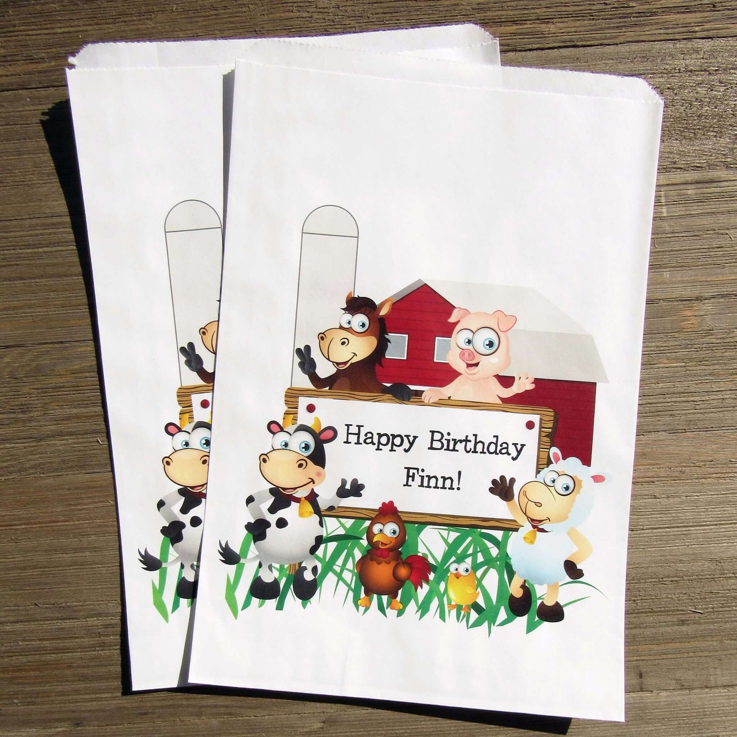 Farm Theme Birthday Party Goodie Bags personalized for the guest of honor.  Printed on white bags, adorned with cute farm animals.  Fill these goodie bags with candy, cookies, popcorn or fun favors.