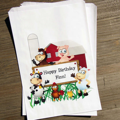 Farm Theme Birthday Party Goodie Bags personalized for the guest of honor.  Printed on white bags, adorned with cute farm animals.  Fill these goodie bags with candy, cookies, popcorn or fun favors.