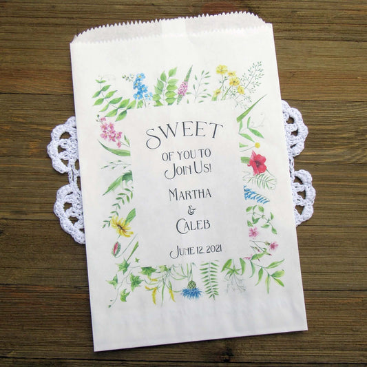 Floral Wedding Candy or Cookie Bags, personalized for the bride and groom.  Printed on white bags with a floral frame around the text.  These bags are larger than most, more room for guests to take home some sweet treats. 