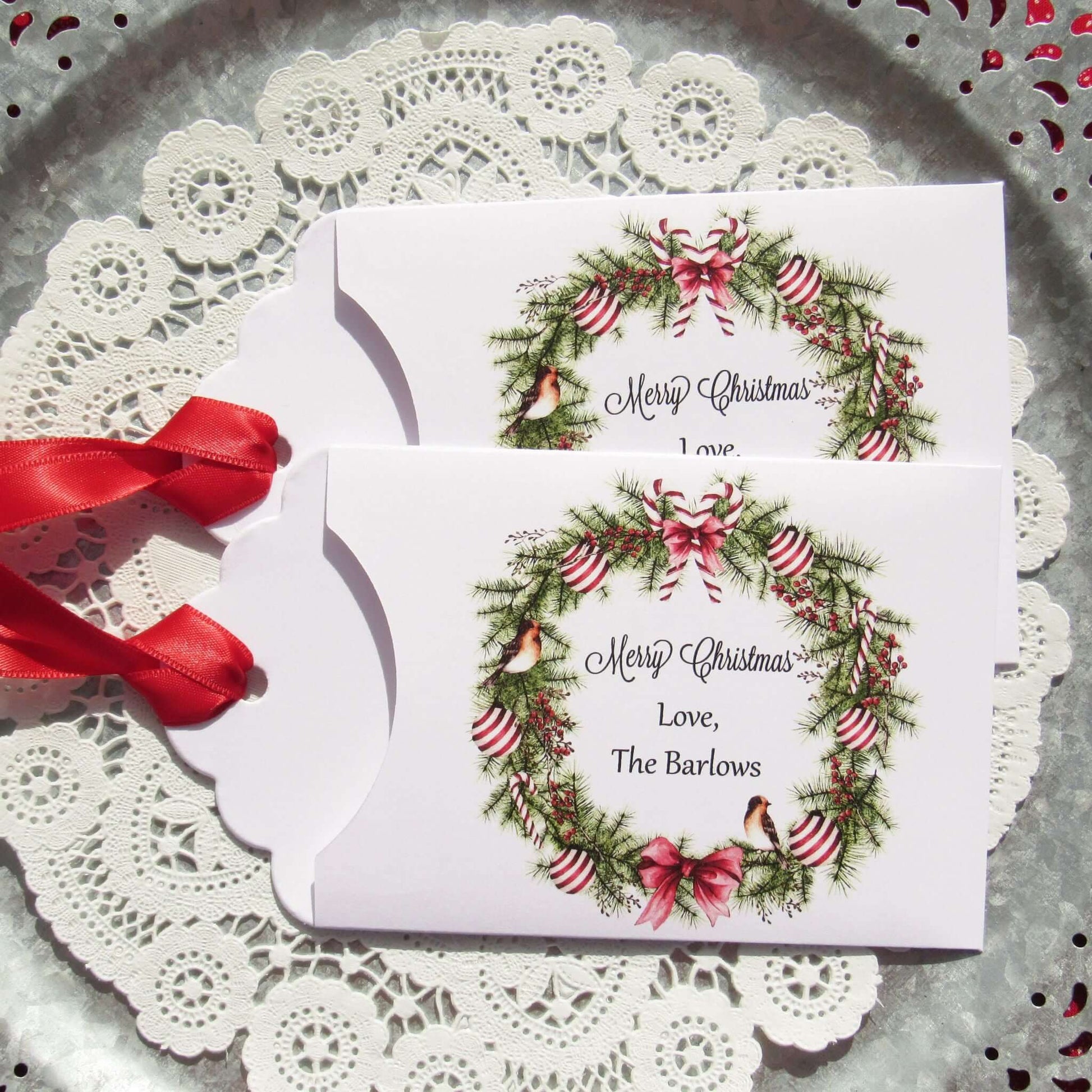 Personalized Christmas Party Favors Affordable Gifts, adorned with a beautiful wreath and a red ribbon attached.  These can be used for lottery ticket favors or gift card holders.