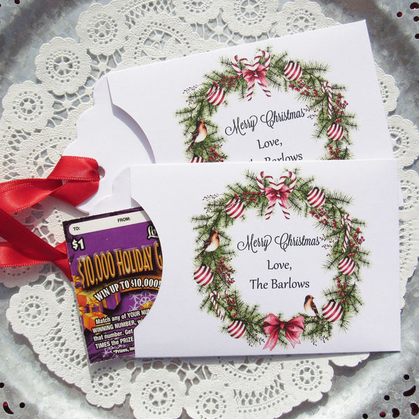 Personalized Christmas Party Favors adorned with a beautiful wreath and a red ribbon attached.  These can be used for lottery ticket favors or gift card holders.