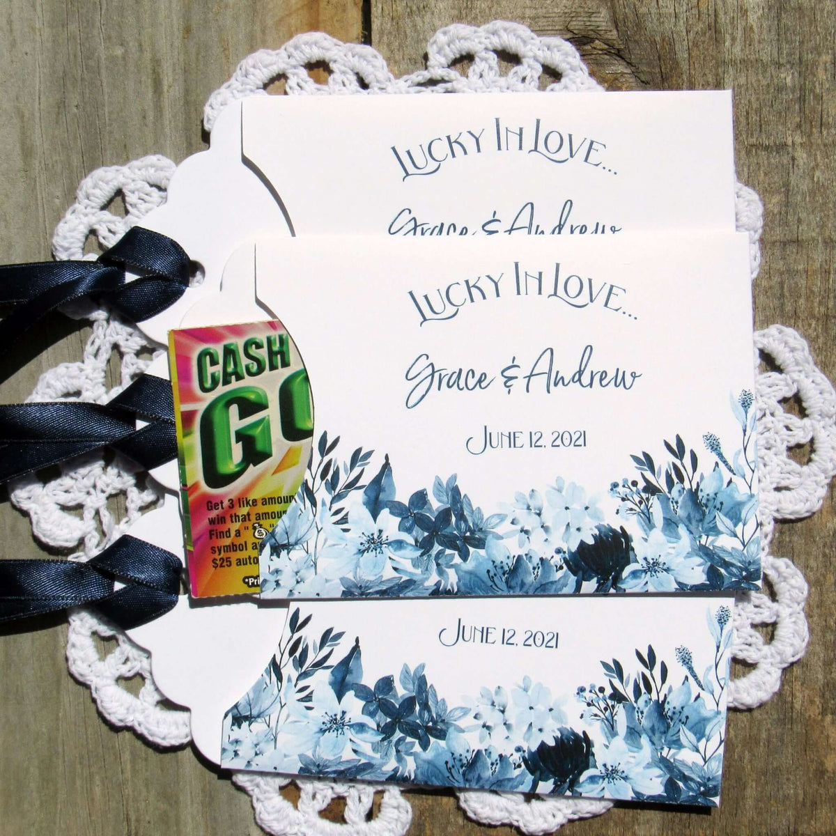 Navy Blue Wedding Guest Favors, slide a lotto ticket in to see who wins.  Envelopes are printed on white card stock adorned with blue flowers and a navy blue ribbon comes attached.  Lucky In Love printed with the bride and grooms names below.  