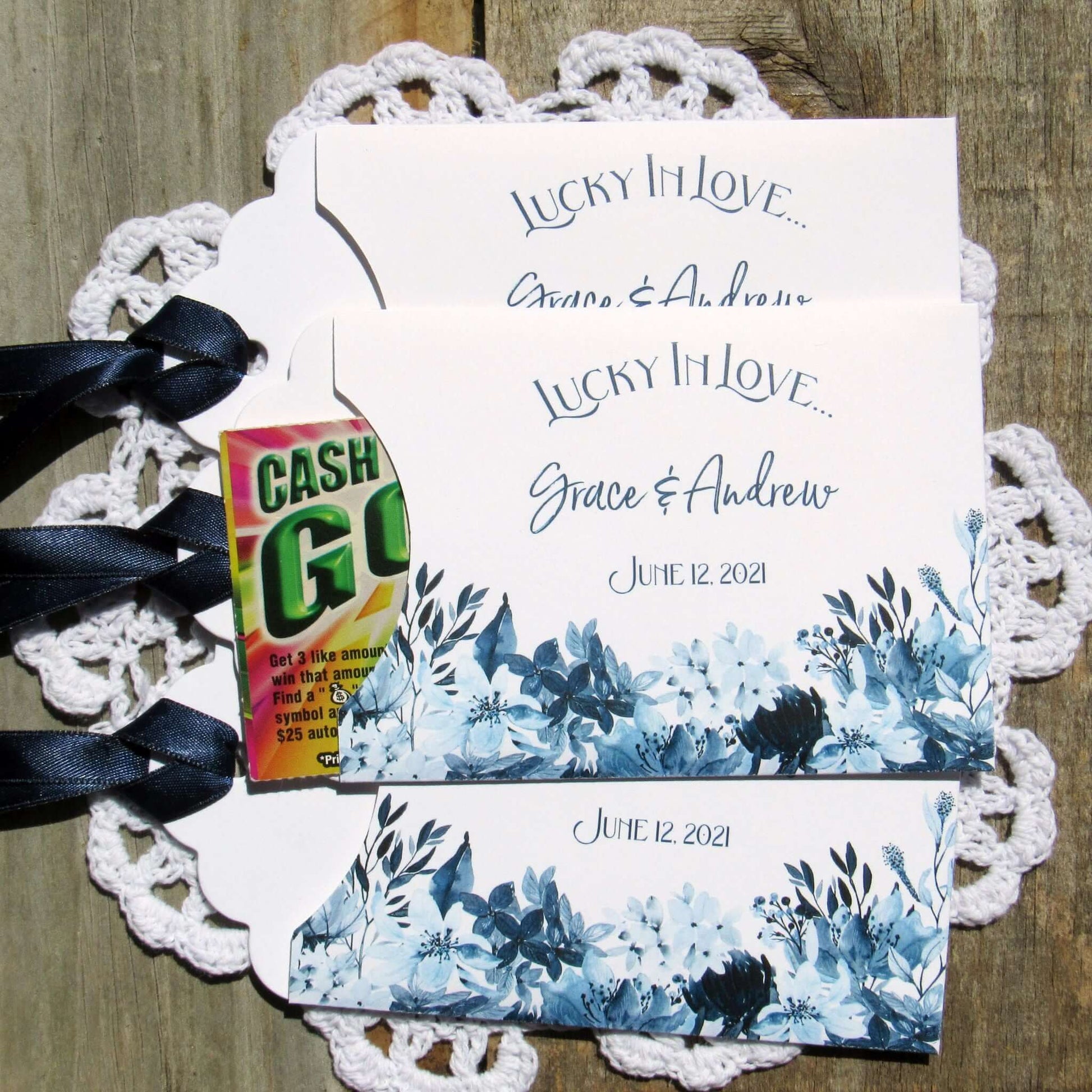 Navy Blue Wedding Guest Favors, slide a lotto ticket in to see who wins.  Envelopes are printed on white card stock adorned with blue flowers and a navy blue ribbon comes attached.  Lucky In Love printed with the bride and grooms names below.  