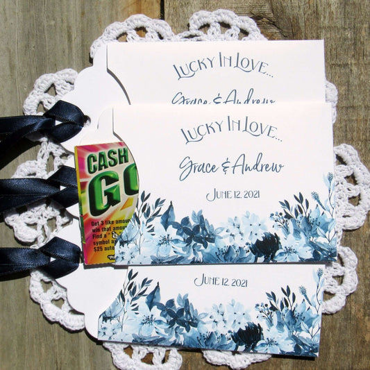 Navy Blue Wedding Guest Favors, slide a lotto ticket in to see who wins.  Envelopes are printed on white card stock adorned with blue flowers and a navy blue ribbon comes attached.  Lucky In Love printed with the bride and grooms names below.  