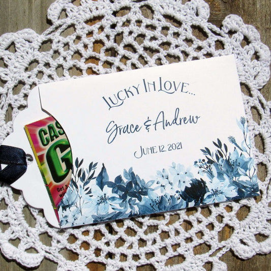 Navy Blue Wedding Guest Favors, slide a lotto ticket in to see who wins.  Envelopes are printed on white card stock adorned with blue flowers and a navy blue ribbon comes attached.  Lucky In Love printed with the bride and grooms names below.  