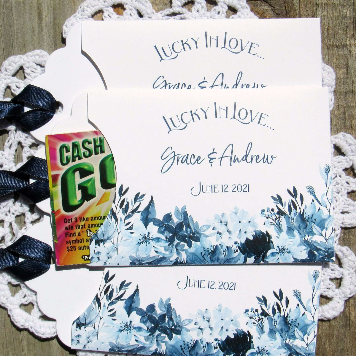 Navy Blue Wedding Guest Favors, slide a lotto ticket in to see who wins.  Envelopes are printed on white card stock adorned with blue flowers and a navy blue ribbon comes attached.  Lucky In Love printed with the bride and grooms names below.  