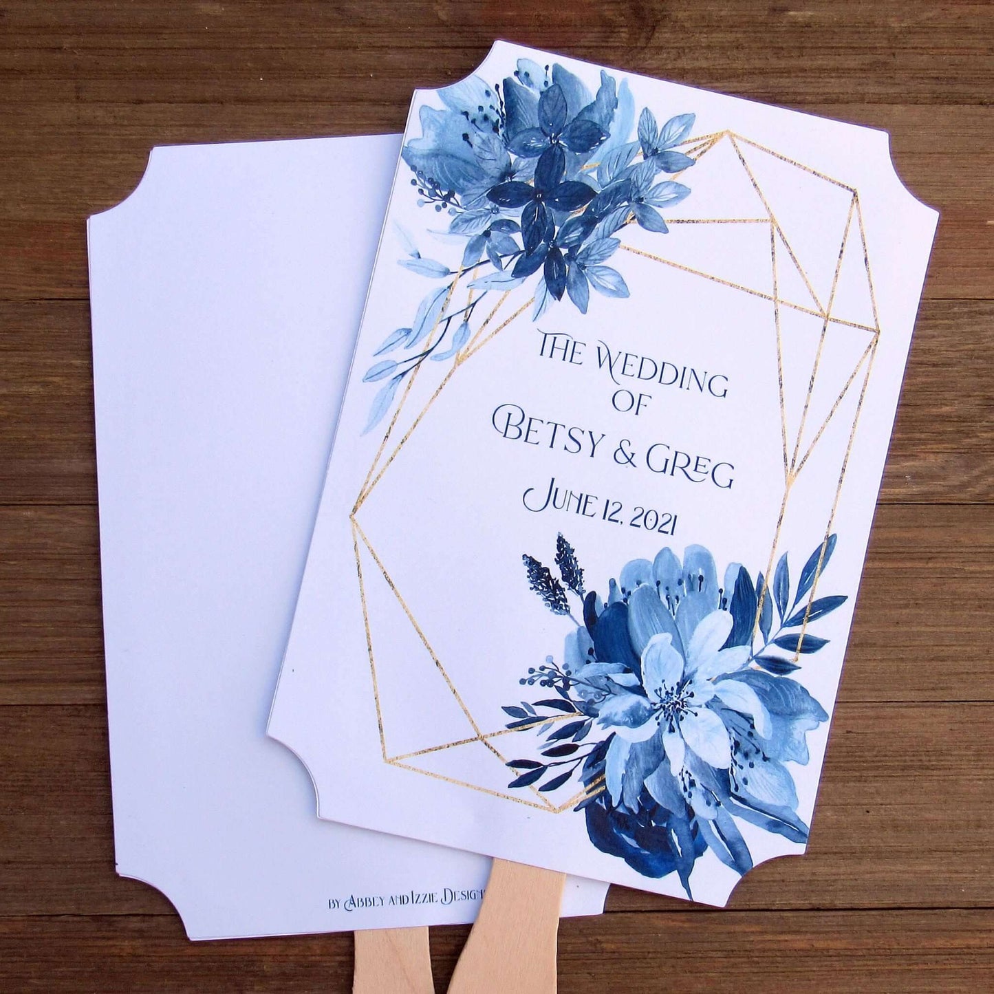 Blue Wedding Fans Assembled with a geometric design gives these fans a modern flare.  Printed on white card stock with blue flowers and personalized for the bride and groom.  Two sided with handle hidden between, printing on one side only.  Fans ship assembled and ready for your special day.
