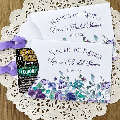 Wishing You Riches Lavender Bridal Shower Lottery Favors are personalized for the bride to be.  Lotto ticket envelopes adorned with lavender flowers and ribbon, slide a lottery ticket in to see who wins big with these fun shower favors.