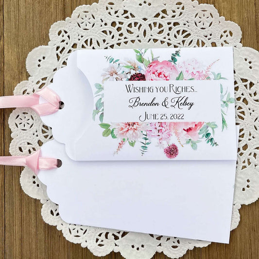 Pink Floral Wedding Favors Personalized  personalized for the bride and groom.  White lottery ticket favors adorned with pink floral with a pink ribbon attached.  Slide a scratch off ticket in for a fun wedding guest favor.