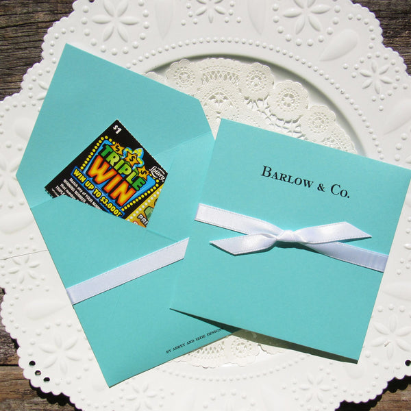 Tiffany blue wedding favors personalized for the newlyweds.  Envelopes made from Tiffany cardstock adorned with a white ribbon which comes attached.  Add a lotto ticket for a fun and easy favor.